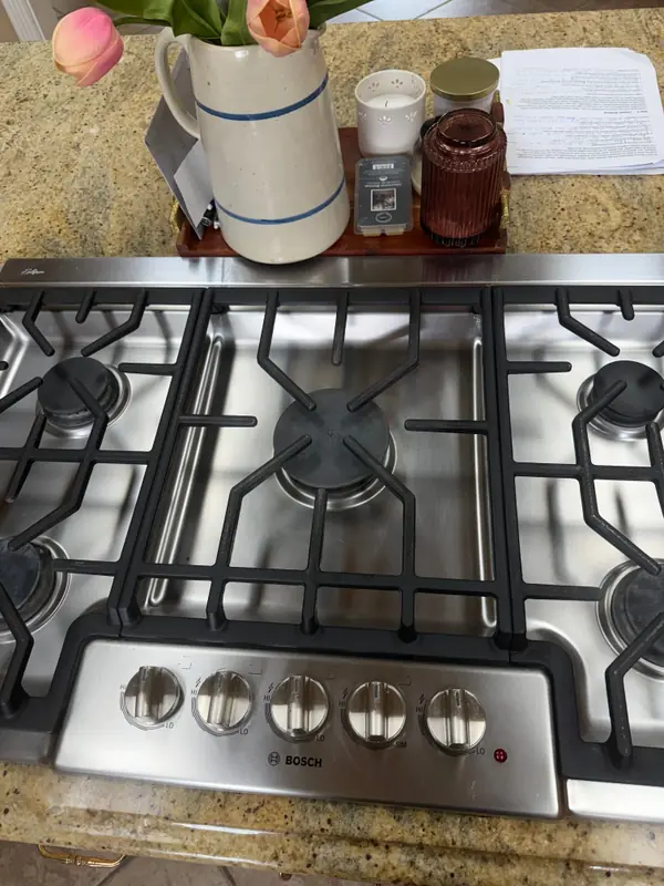The same gas cooktop, spotless after cleaning