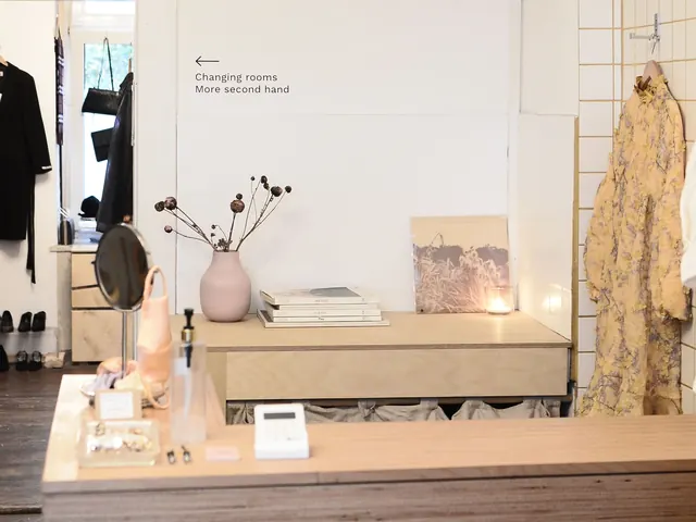 Bright boutique with a wooden sales counter, card reader and clothes on hangers